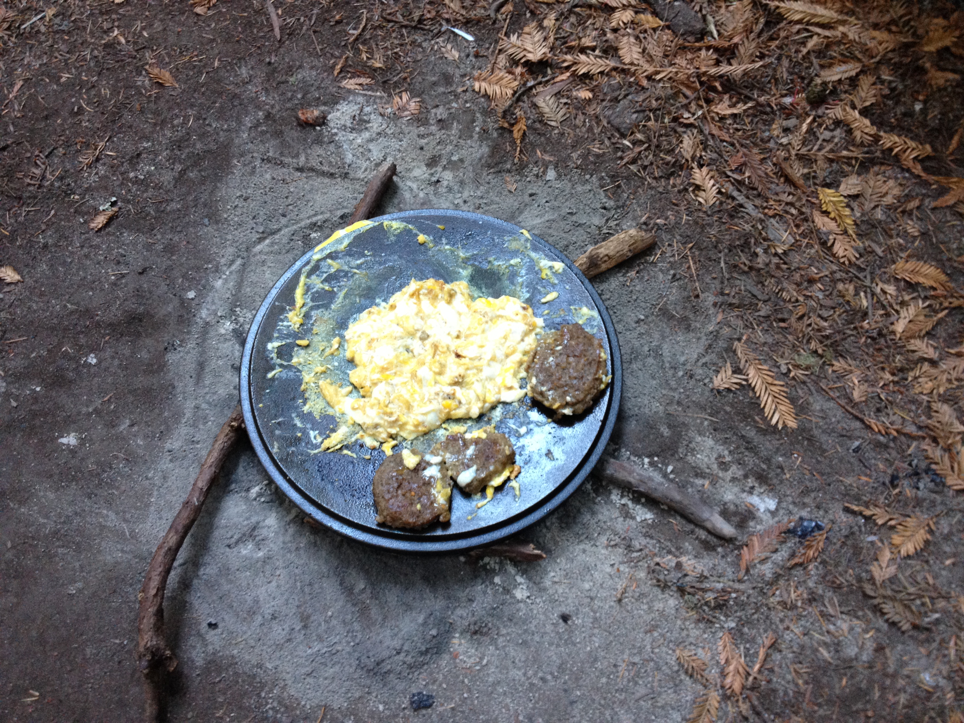 Cooking while camping. Dutch oven lid eggs and sausage.